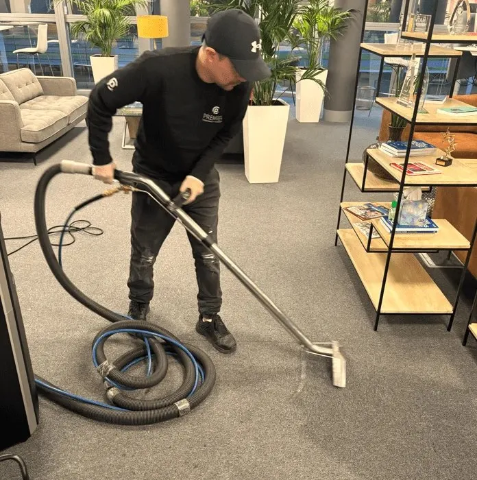 Premier technician deep cleaning office carpet with an extraction machine