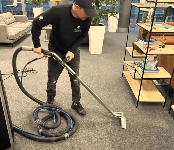 Premier technician deep cleaning carpet with an extraction machine