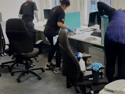 Premier team deep cleaning desks and chairs in an open-plan office