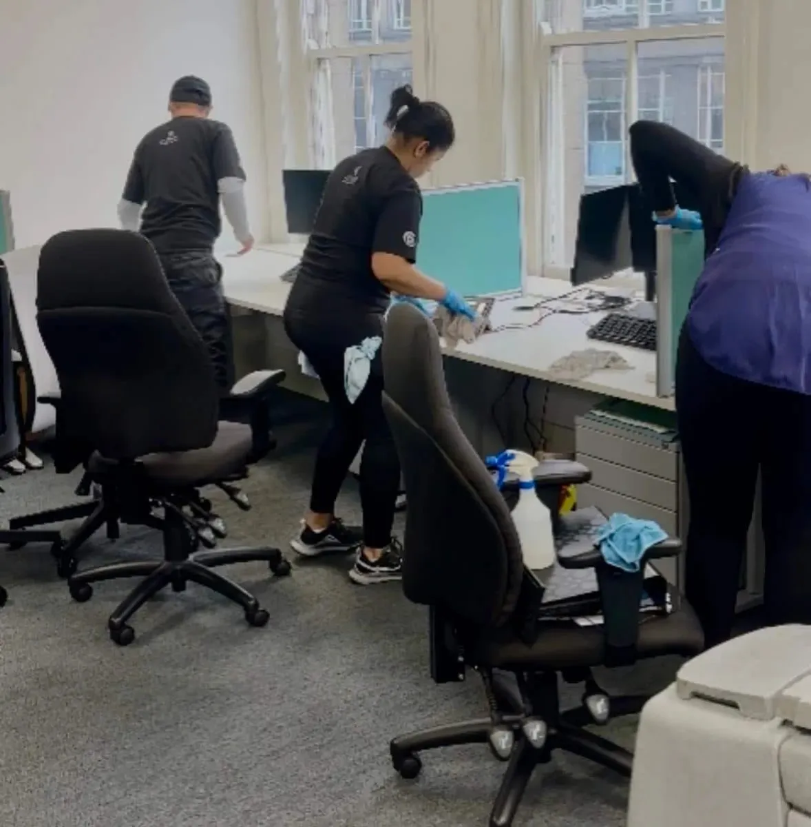 Premier team deep cleaning desks and chairs in an open-plan office