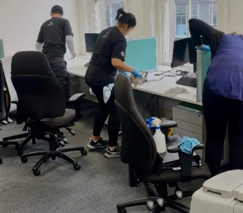 Premier team deep cleaning desks and chairs in an open-plan office