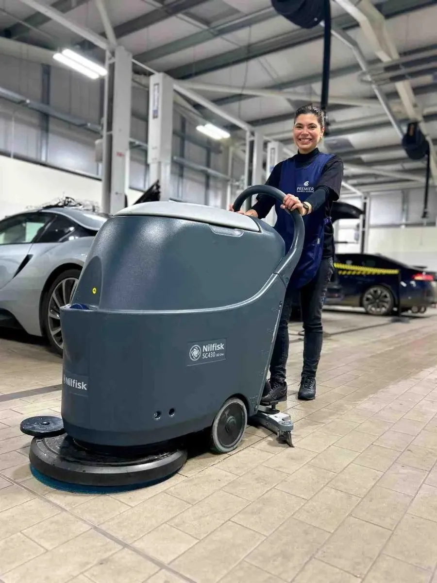Premier cleaner using a scrubber dryer on a car showroom floor