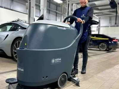 Premier cleaner using a scrubber dryer on a car showroom floor