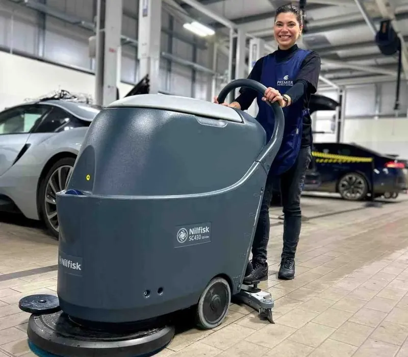 Premier cleaner using a scrubber dryer on a car showroom floor
