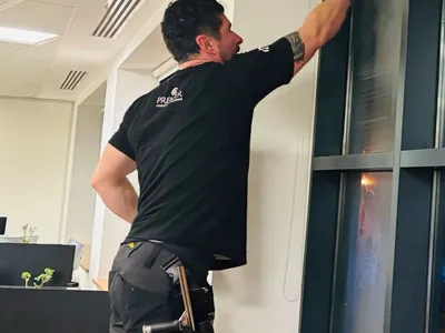 Premier cleaner cleaning a tall window frame